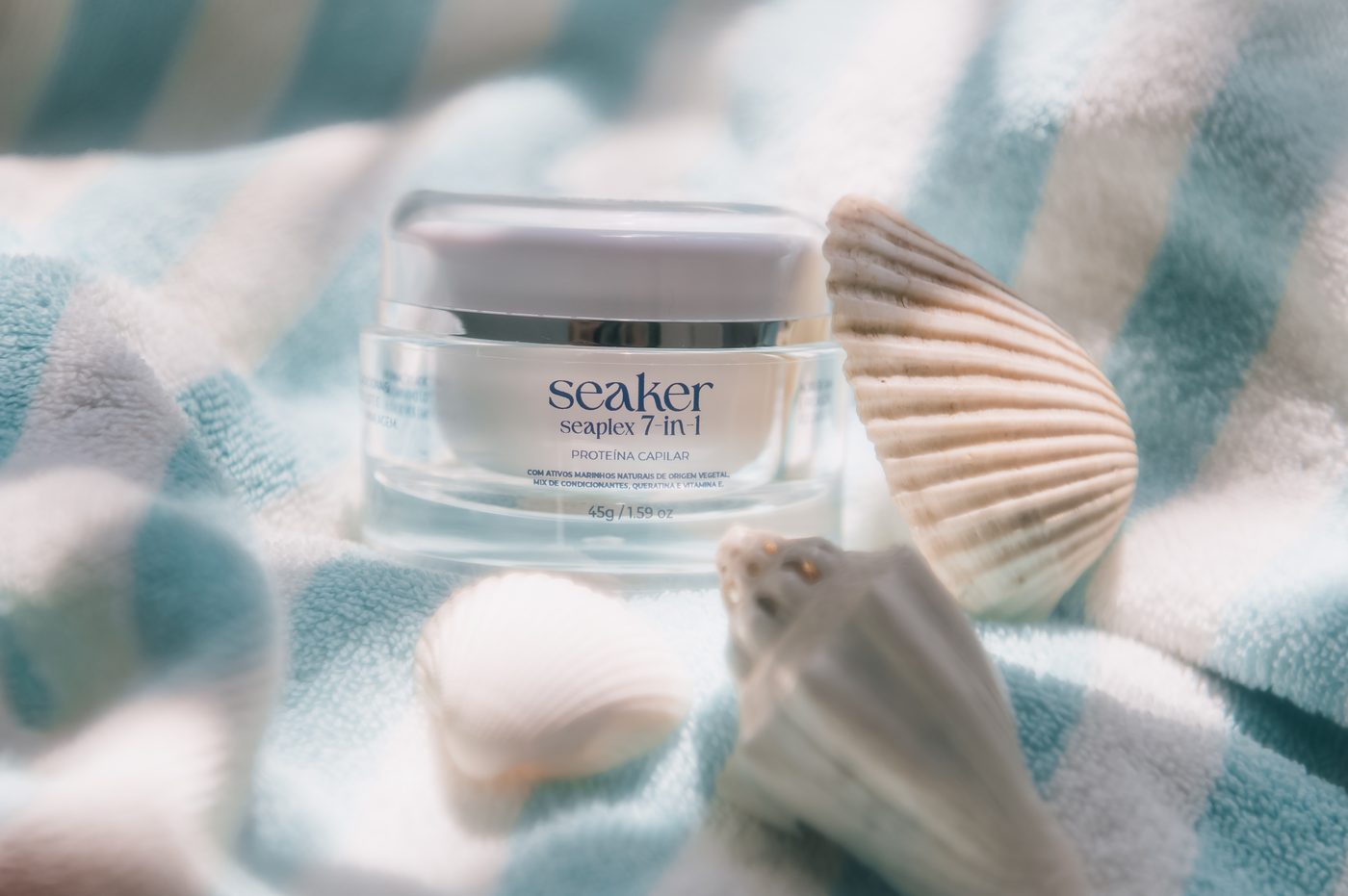 Produto Seaker em composição clara com conchas e textura de praia